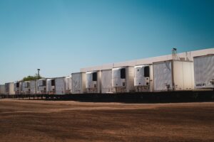 Fila de contenedores refrigerados reefer estacionados en un patio de logística bajo cielo despejado