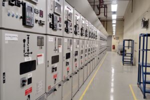 Interior de una sala eléctrica industrial con tableros y gabinetes de control en una faena minera
